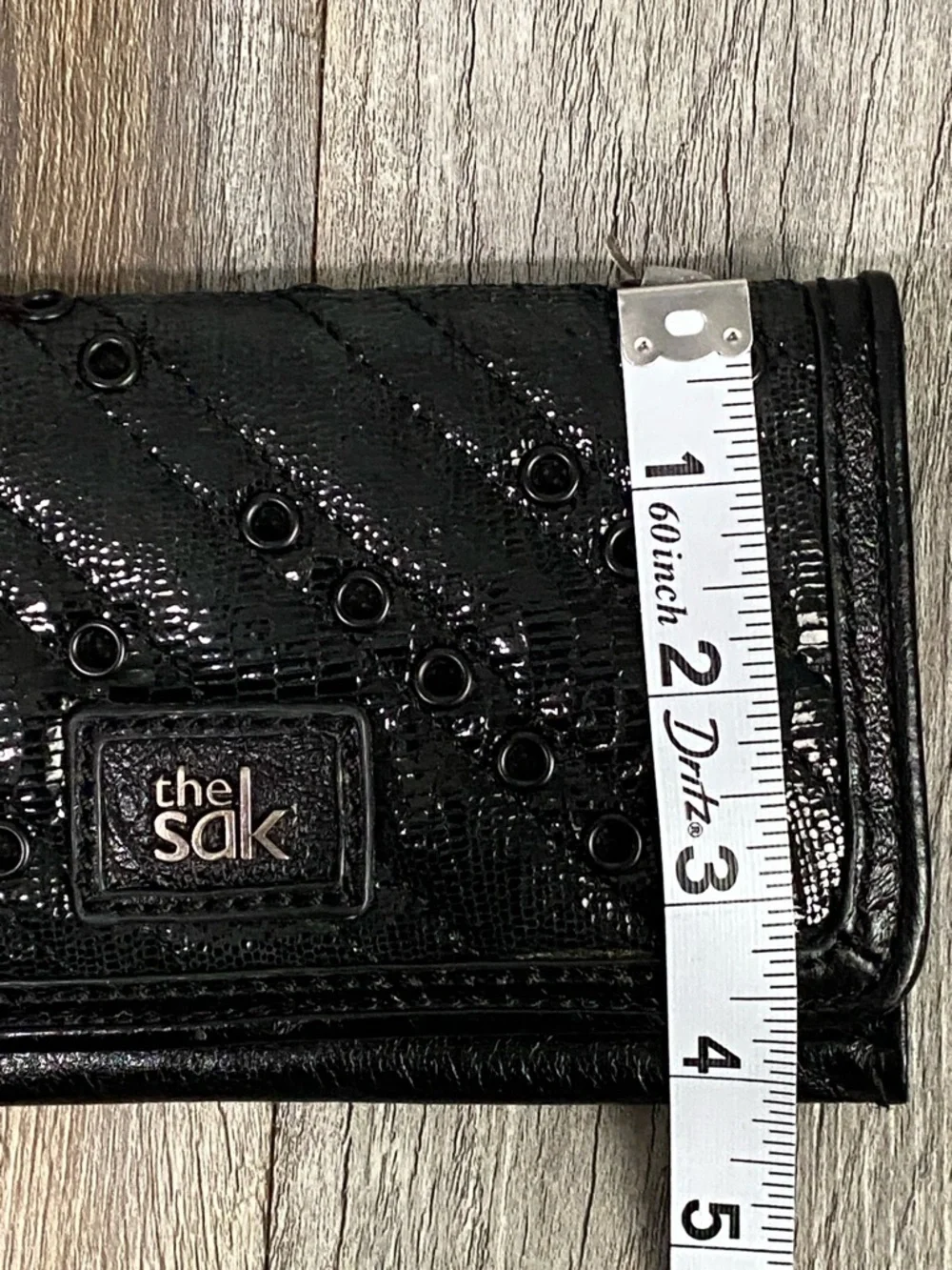 The Sak Black Quilted Eyelet Trifold Leather Wallet with Logo Plaque